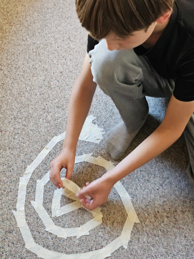 A camper building a large geometric structure at Summer Learning Labs