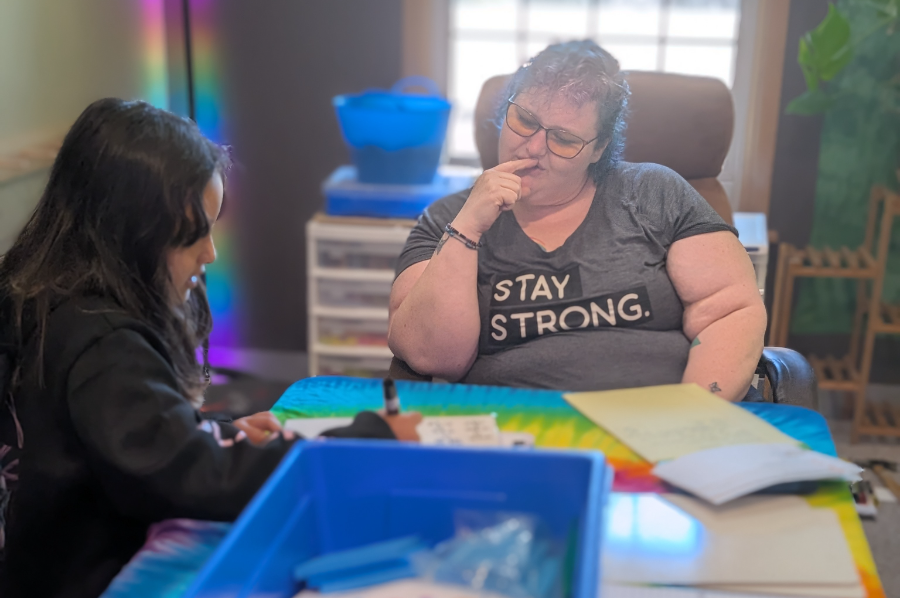 Dori Isakson working one-on-one with a student at the rainbow table