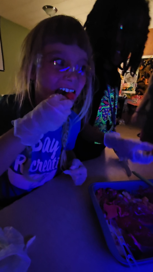 A student glowing under blacklight at Glow Lab