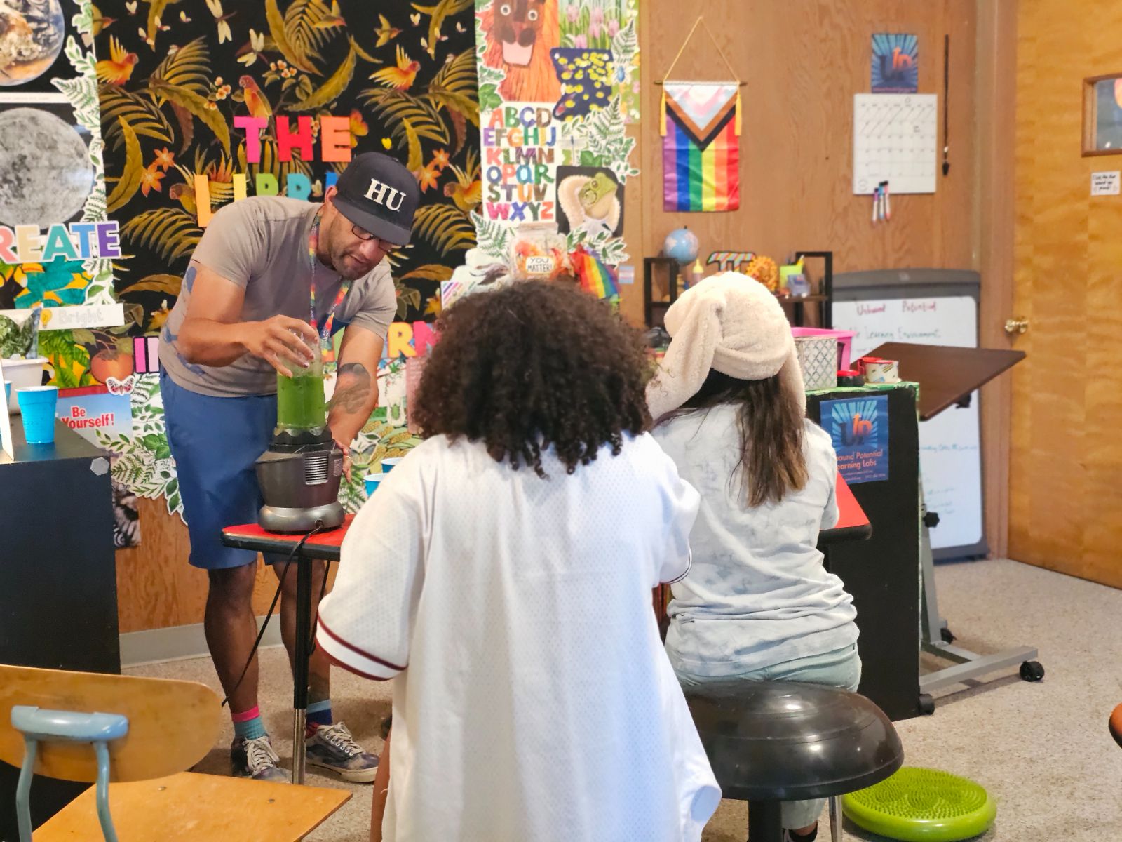 Todd Valentine blending a green smoothie while two students watch at a Learning Lab